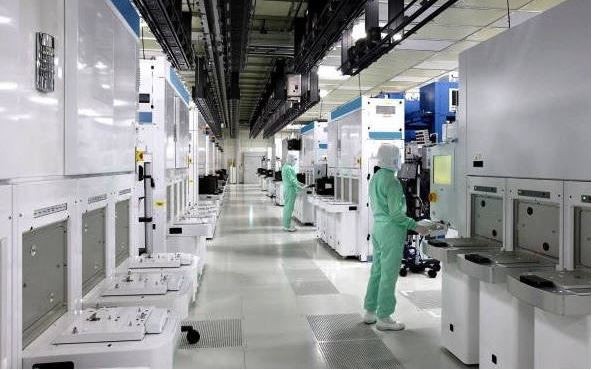 Technicians operate in a clean room of Toshiba’s New Fab2 plant in Yokkaichi, Japan.